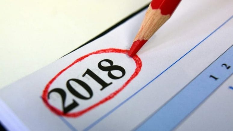 Red pencil sitting on a calendar with the year 2018 circled in red