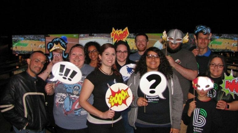 InCheck employees pose with superhero props in a bowling alley