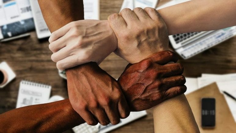 four hands of different ethnicities interlocked